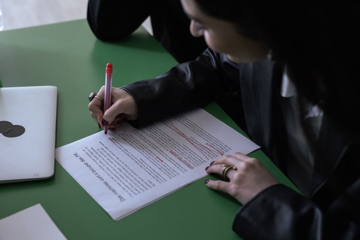 A printed document being marked up with a red pen