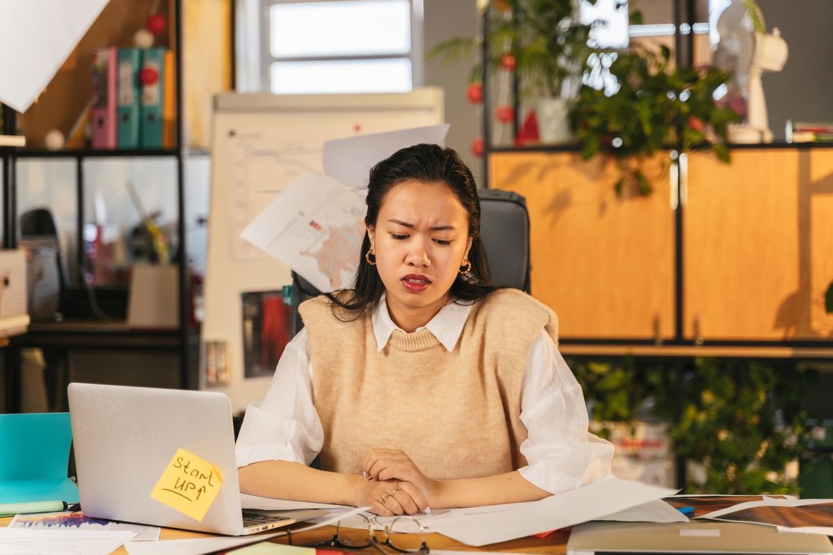 An office worker at a desk buried in paperwork on a bad day